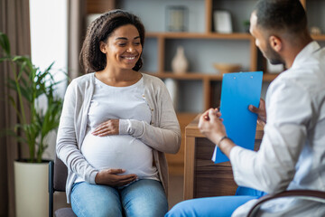 Pregnant black woman visiting doctor at private clinic