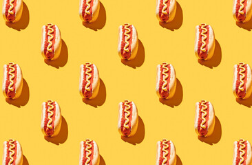 Pattern of fresh made hot dogs on yellow pastel background