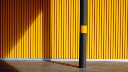 sidewalk with yellow metal wall