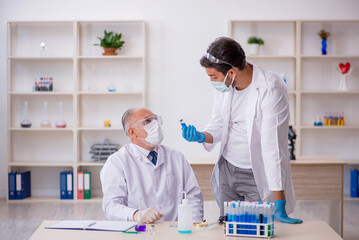 Two male chemist working at the lab