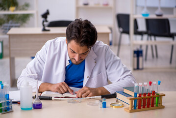Young male chemist working at the lab