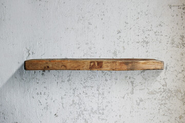 Wooden shelf on a white old wall.