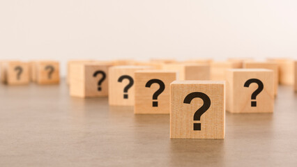 front view on many wood cubes with question marks. many question arising concept