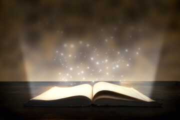 Magic book with a beam of bright light and sparks, learning concept