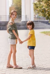 Foto op Plexiglas twee meisjes in het park hand in hand © Albert Ziganshin