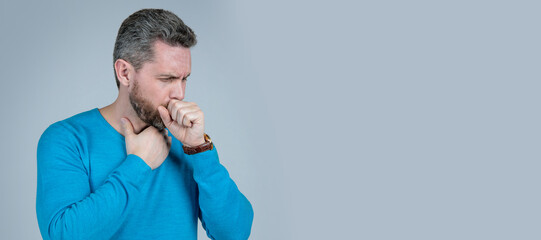 mature man with beard has cough suffer from sore throat on grey background, mens health. Man face...