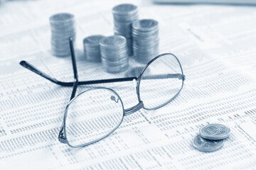 Letterbox view of pile of silver coins lying at financial chart document close-up