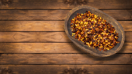Crushed red chili peppers in the wooden bowl