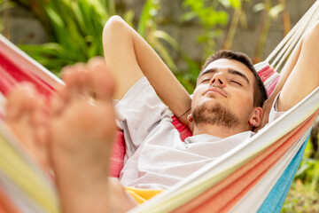 young man sleeping in the hammock in summer