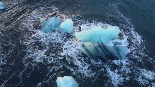 Iceberg in the ocean, Huge Chunks of Blue Ice floating on the waves, Beautiful arctic landscape aerial top view, global warming and climate change concept