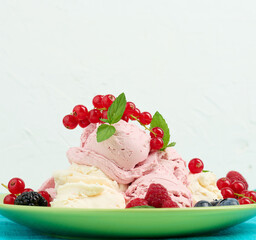 Vanilla and raspberry ice cream scoops on a round green plate