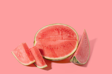 Cut watermelon on red pastel background