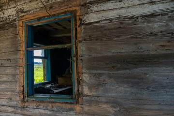 An old wooden uninhabited house. A small house in the village with a sunken roof and walls overgrown with moss. Destroyed housing after the cataclysm and poverty in Russia.