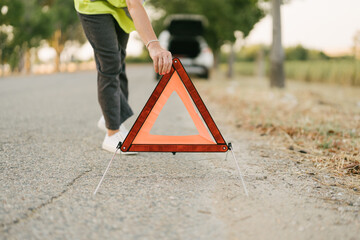 woman placing the emergency triangle on the road