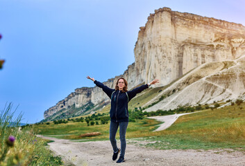 girl stands at the foot of the mountain