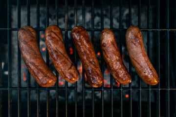 Sausage. Outdoor cooking. Professional grill. Fresh, Mild Italian Sausage. Hot red charcoal in the grill. Bbq or Barbecue. Cook out restaurant. Delicious dinner. Food photo. Flat lay with copy space. 