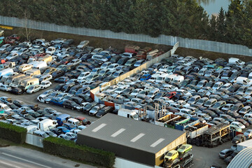 Aerial view of big parking lot of junkyard with rows of discarded broken cars. Recycling of old vehicles