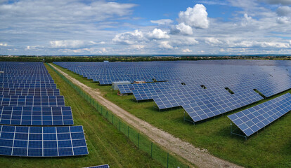 Aerial view of large sustainable electrical power plant with rows of solar photovoltaic panels for...