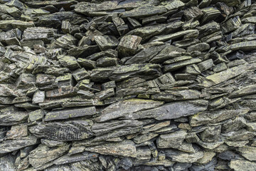 stone wall background from weathered slate stones