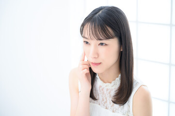 Fototapeta premium ニキビを気にする若い女性 左にコピースペースあり