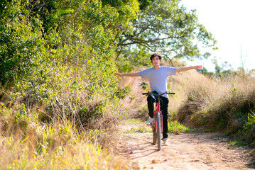 Young happy man riding a bicycle on the trail and having fun. Man having fun and enjoying life