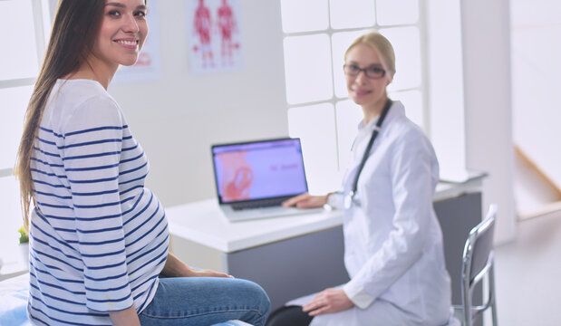Beautiful smiling pregnant woman with the doctor at hospital