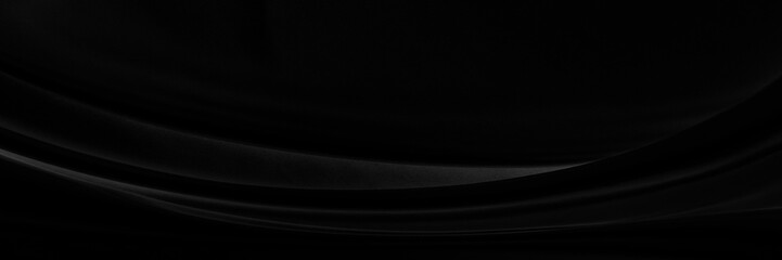 Black gray satin dark fabric texture luxurious shiny that is abstract silk cloth panorama background with patterns soft waves blur beautiful.