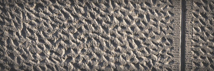 Wall with decorative imitation of stone blocks. Rough surface, painted in brown color. Wide panoramic texture for background and design.