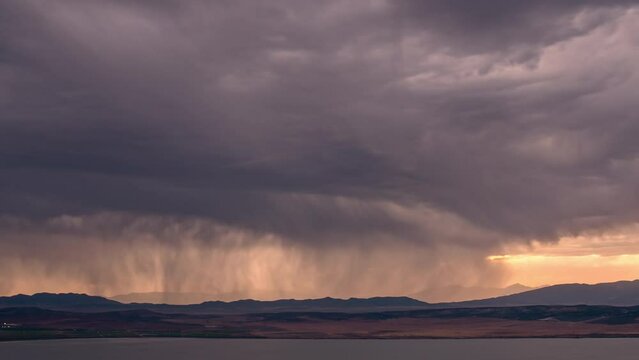 Time lapse of storm moving over the landscape at sunset on the edge of Utah Lake.