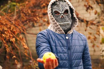 Defocus Halloween people portrait. Person in grim reaper mask standing on nature autumn background...
