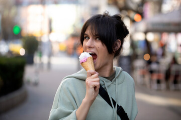 woman eating cream. Ice cream. People. City background. Sensual. Lifestyle. Food. 