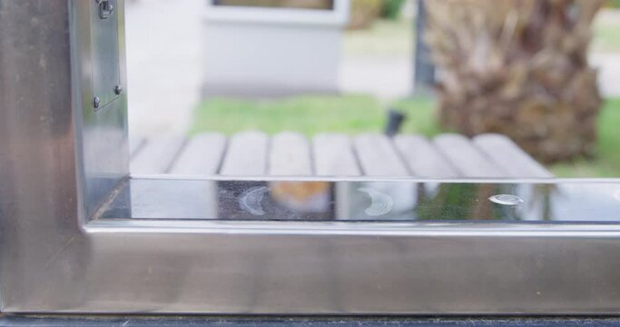 Person picks up a mobile phone in silicon case from a wireless charging station, which is located in a public place and uses solar energy as a source of electricity, close up
