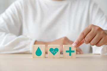 Healthcare and medical concept on wooden blocks and woman at the back. Woman in white cloth and health concept sign in wood cube.