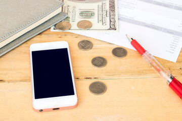 mobile, money, statement and notebook planner for business work arrangement flat lay style on background wooden