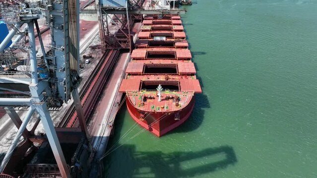Cranes Unloading Commodities From a Bulk Carrier Ship at Port