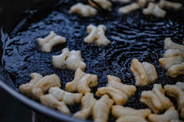 Flour is fried in a pan with hot oil as a fried dough stick to eat with coffee or dipped in sweetened condensed milk. It is sold in Thai roadside markets.