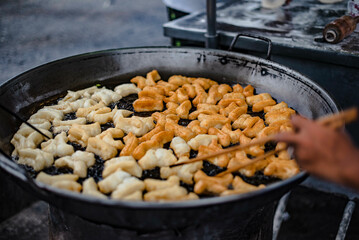 Flour is fried in a pan with hot oil as a fried dough stick to eat with coffee or dipped in sweetened condensed milk. It is sold in Thai roadside markets.