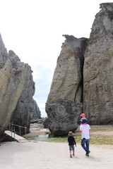 大きな岩の間を歩いていく親子