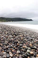 Fototapeta na wymiar 宝石のような石が集まる浜辺
