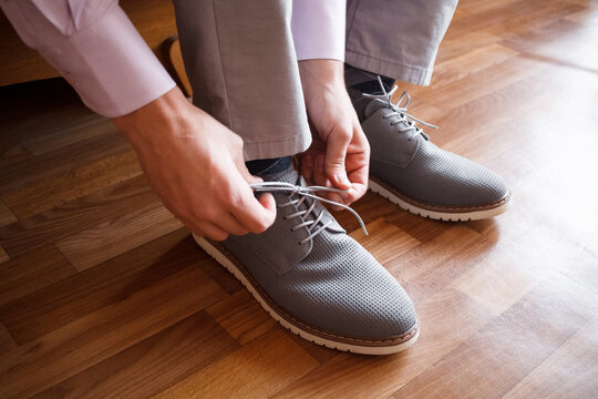 A man put on grey shoes © Natalie