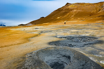 Bright blue holes with bubbling sulphur mud in geothermal area in Northern Iceland