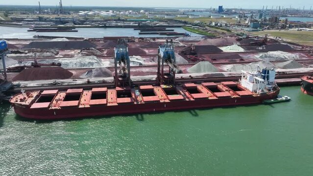 Cranes Unloading Commodities From a Bulk Carrier Ship at Port