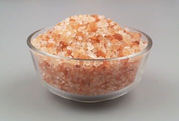 Fototapeta na wymiar Himalayan pink salt in glass bowl on gray background 