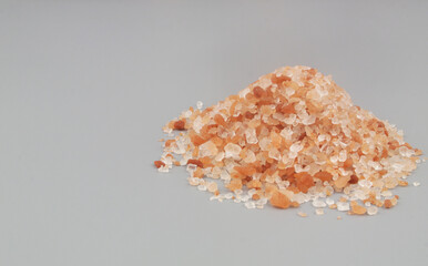 Fototapeta na wymiar Himalayan pink rock salt on gray background with room for text