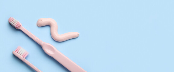Sample of toothpaste and brushes on blue background with space for text