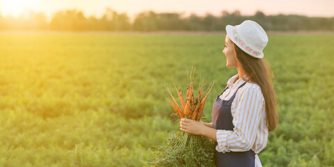 Female farmer with carrot in field