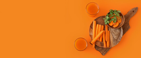 Glasses of tasty carrot juice on orange background with space for text