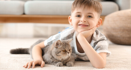 Happy little boy with cute cat at home