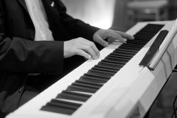 Obraz premium Hand playing electric organ on stage