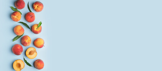 Many ripe peaches on light blue background with space for text